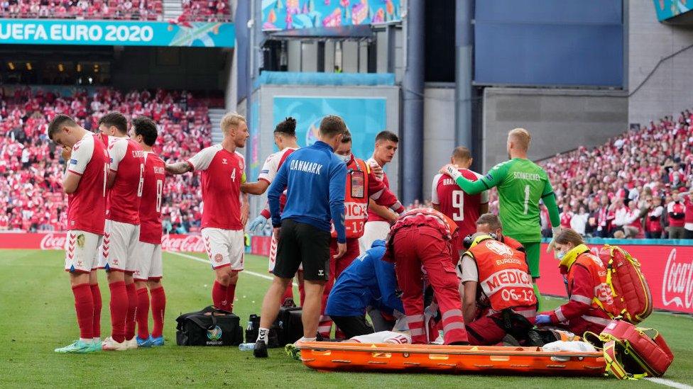 Eriksen being attended to by medics Image
